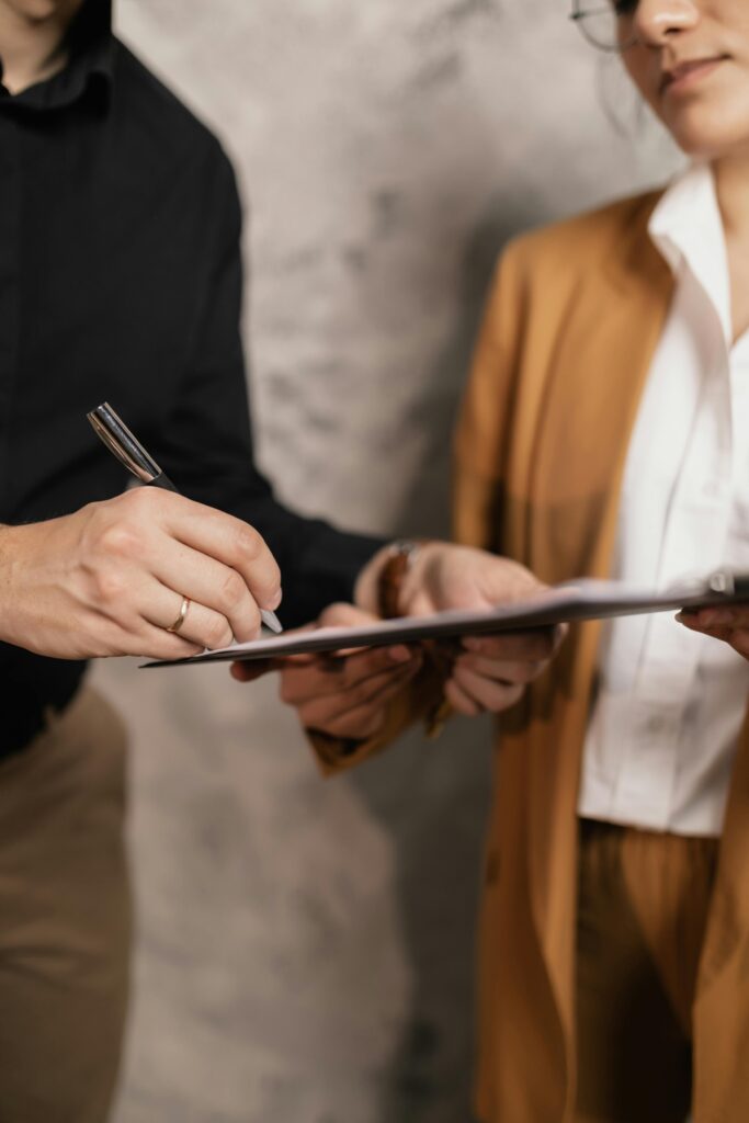 pexels-photo-7641990-7641990 Close-up of two professionals signing a business document, emphasizing collaboration and negotiation.